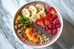 Smoothie bowl making with banana, chia seeds, granola and berries photo