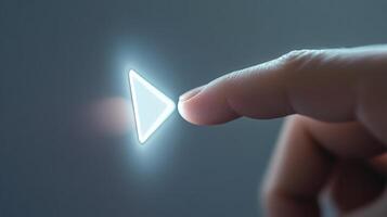 Finger touching glowing play button starting playback photo
