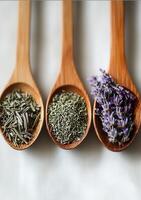 Wooden spoons showing dried herbs and lavender flowers on white background photo