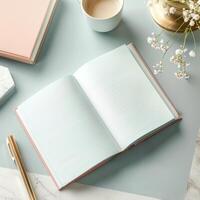 Open notebook, pen, cup of coffee and flowers on marble table photo