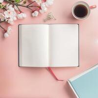 Open book, coffee and flowers on pink background photo