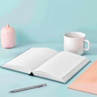Open notebook, pen, coffee mug and notebook on blue background photo