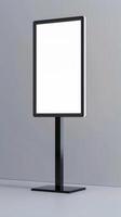 A blank white sign on a stand in front of a gray wall photo