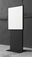 A black and white billboard stands on a concrete floor photo