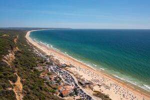 Aerial drone view of crowded Fonte de Telha beach with idyllic ocean photo
