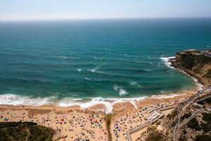 Aerial view of Magoito Beach with tourists and ocean waves in Sintra photo