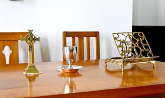 a wooden table with a cross and a vase on it photo