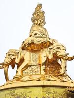 a golden statue of a buddha on top of a building photo