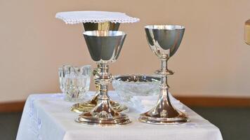 a table with silver goblets and a cloth on it photo