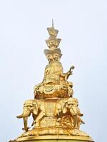 golden buddha statue on top of a building photo