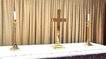 a gold cross and two candles on a table photo