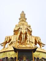 a golden statue of an elephant with buddha sitting on it photo