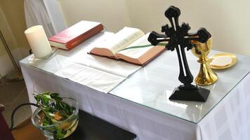 a cross sits on a table with a book and candle photo