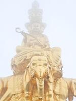 a statue of buddha sitting on top of an elephant photo