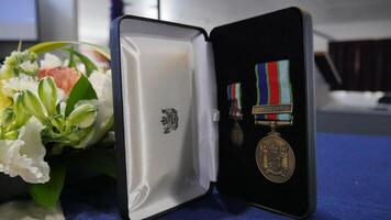 a medal and a flower are in a case on a table photo