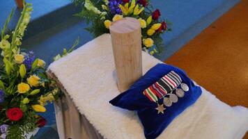 wooden cross with medals and flowers on it photo