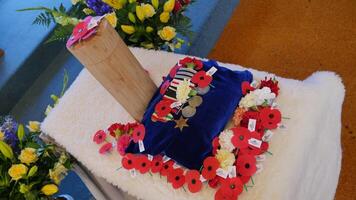 a wooden cross with poppies and flowers on it photo