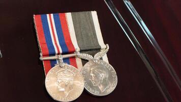 two medals are on a wooden surface with a ribbon photo