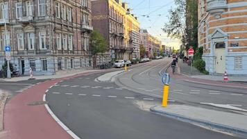 amsterdam. Países Baixos 02.02.2025 amsterdam rua com eléctrico faixas, ciclistas, e histórico arquitetura dentro dourado tarde luz video