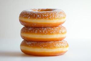 Stack of three sugary glazed donuts on white background. photo