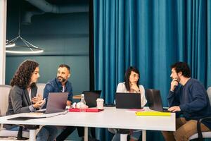 Group of multiracial people working with laptop in a coworking. Doscussion in progress photo