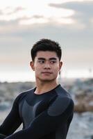 Ethnic sportsman stretching near sea photo
