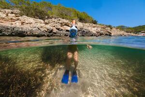 Anonymous boy in snorkeling mask in ocean photo