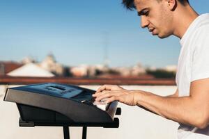 man playing piano on an urban rooftop alone photo