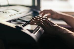 man playing the piano close-up. musical keyboard photo
