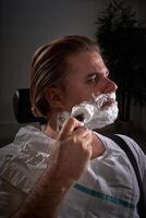 Man applying shaving foam in barbershop photo