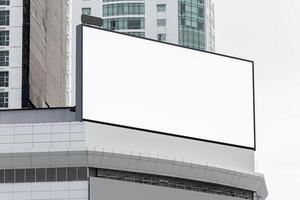 Mock up white horizontal large LED display billboard on rooftop building. clipping path for mockup photo