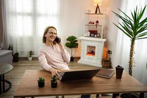 Enjoying a cozy moment at home while having a cheerful conversation on the phone during a sunny afternoon photo
