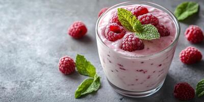 Creamy raspberry dessert with fresh mint on a rustic gray background in natural light photo