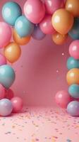 Colorful balloon arch decorated with confetti for a festive celebration in a pink setting photo
