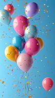 Colorful balloons float against a blue background surrounded by shimmering confetti celebrating a festive occasion photo
