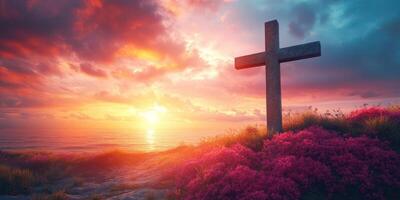 Beautiful sunset over the ocean with a cross surrounded by vibrant flowers on a serene coastline photo