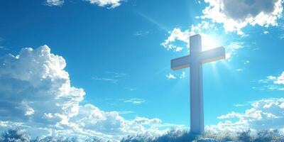 Tall cross stands against a bright blue sky with fluffy clouds in a peaceful landscape during daylight hours photo