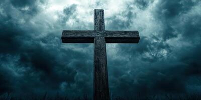 Wooden cross stands in a dark, stormy sky with ominous clouds above a quiet landscape photo