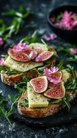 Delicious open-faced sandwich topped with figs, cheese, and flowers on a rustic table photo