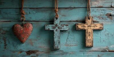Rustic wooden crosses and a heart hang against a textured blue background in a tranquil setting photo