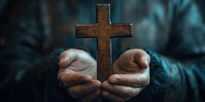 Hands holding a weathered cross symbolizing faith and spirituality in a serene setting photo