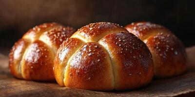 Freshly baked rolls with a golden crust and a sprinkle of coarse salt on a rustic wooden surface photo