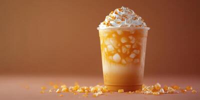 Sweet frozen beverage topped with cream and caramel served in a clear cup on a warm background photo