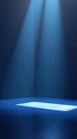 Bright blue spotlights illuminate an empty stage creating an atmosphere of anticipation and creativity in a dark room photo