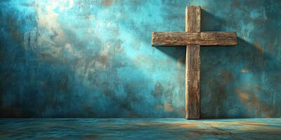 Rustic wooden cross stands against a textured blue wall reflecting natural light in a serene setting photo