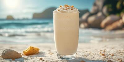 Creamy beverage served on sandy beach with ocean view and sunlight in the background at a relaxing coastal getaway photo