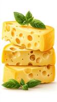 Cheese blocks stacked with fresh basil leaves on a wooden surface in a rustic kitchen setting photo