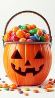 Colorful Halloween candies overflowing from a pumpkin-shaped bucket during a festive celebration photo