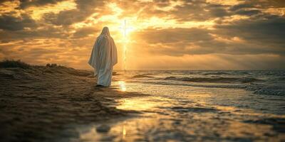 Individual in white robe walking along shoreline towards sunset with a glowing cross in the background photo