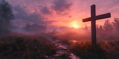 Sunset behind a wooden cross in a misty landscape with a winding path and silhouettes of trees photo